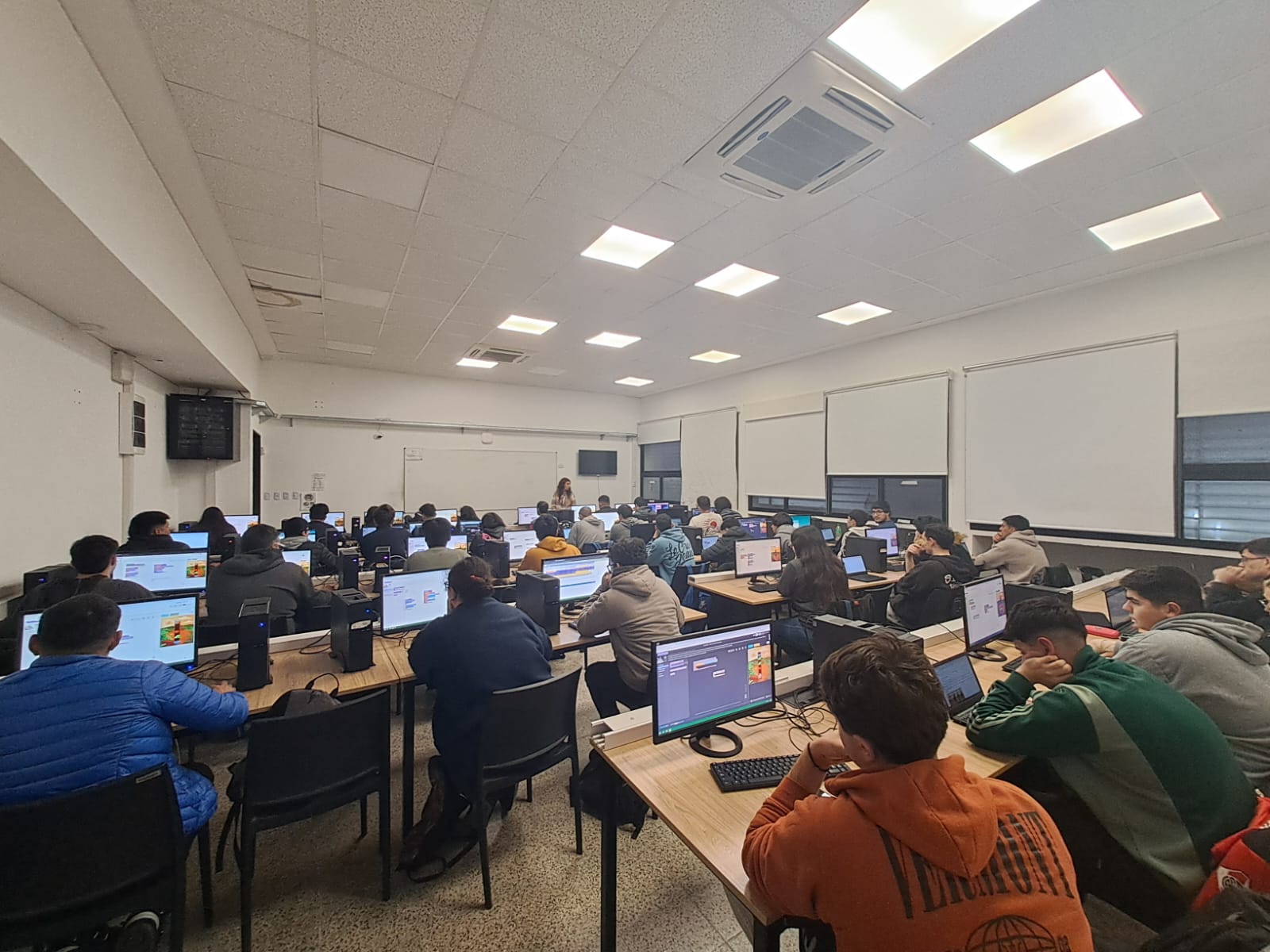 Docente acompañando la resolución de una actividad de programación